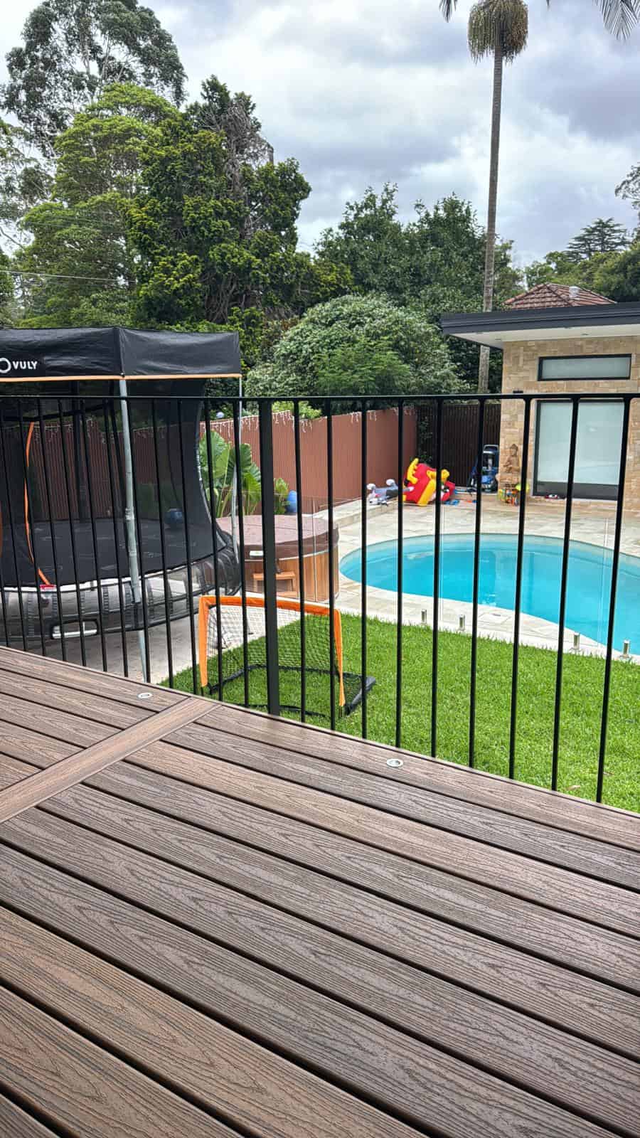 Completed high-end rear yard landscape construction featuring interlocking paving and an architectural boundary wall.